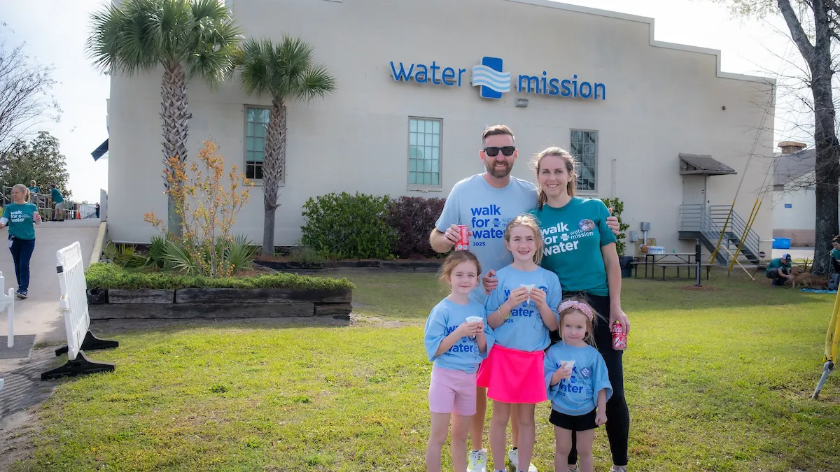 Family poses in front of Water Mission headquarters