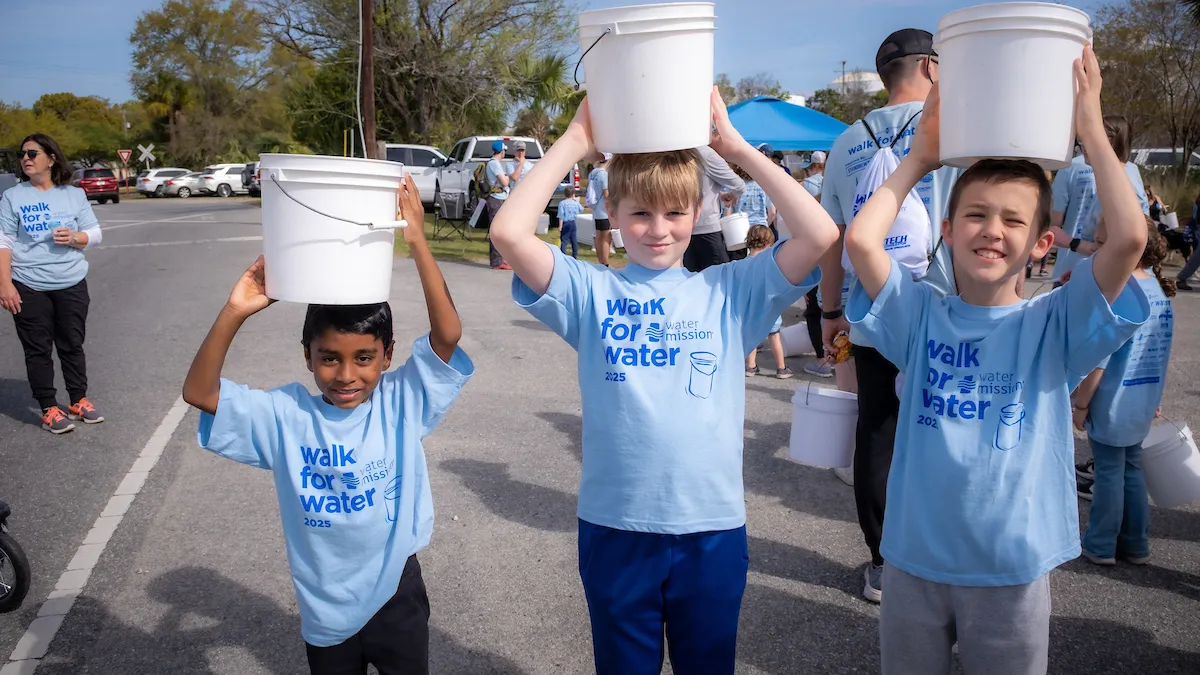 Young walkers hold buckets over their head
