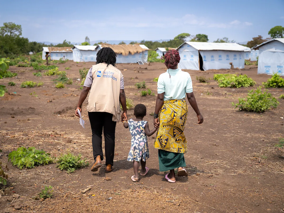 A Water Mission Team Member Walks with a Family in Tanzania