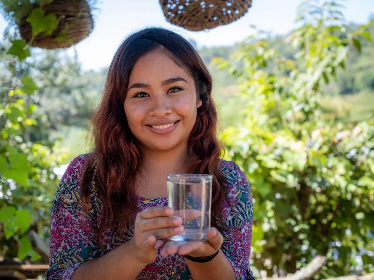 A young woman holds a glass of safe water in La Union, Mexico. Your water bill could make safe water like this possible in more communities around the world.