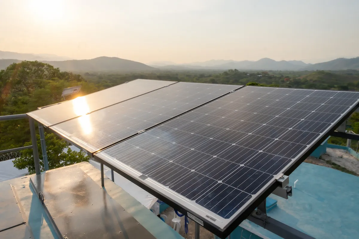 The sun shines on an array of solar panels.