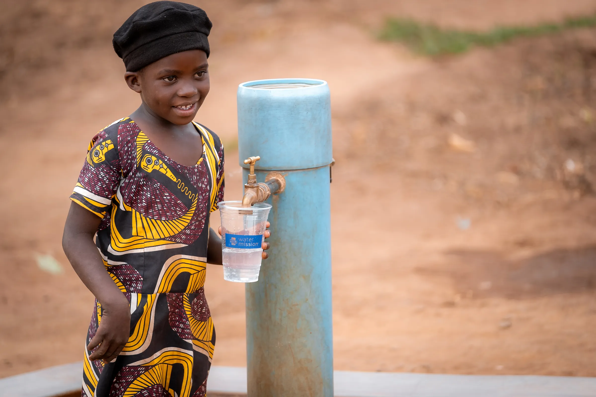 A young girl collects safe water from a tap stand in Mankhana Dwangwa, Malawi