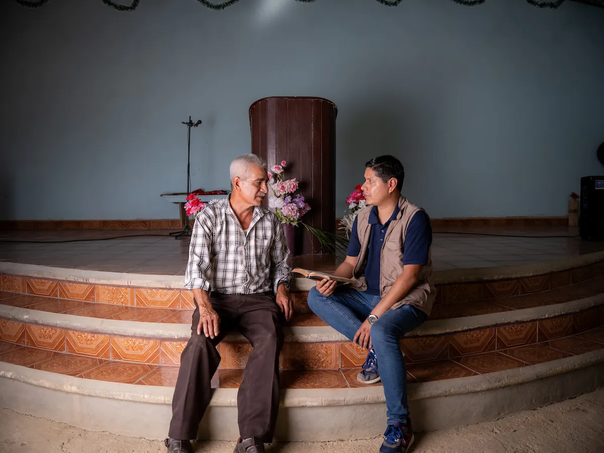 Two men sit in a church