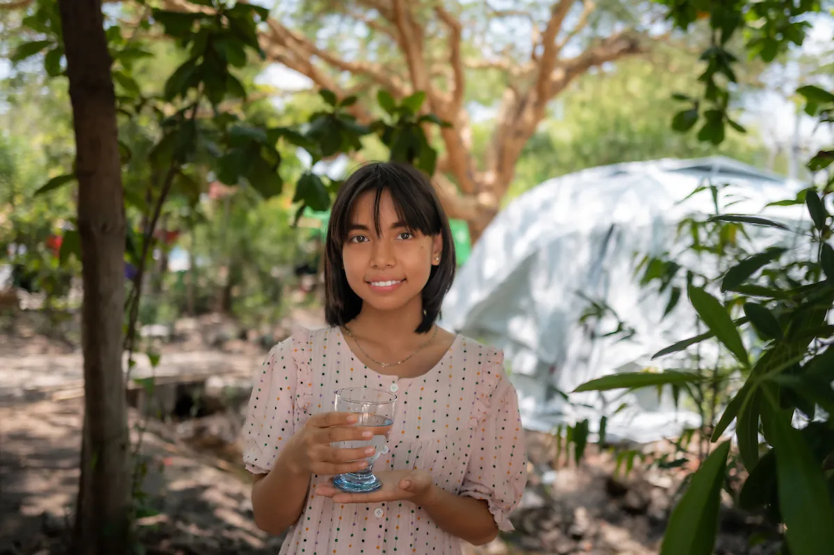 Young girl holds cup of water