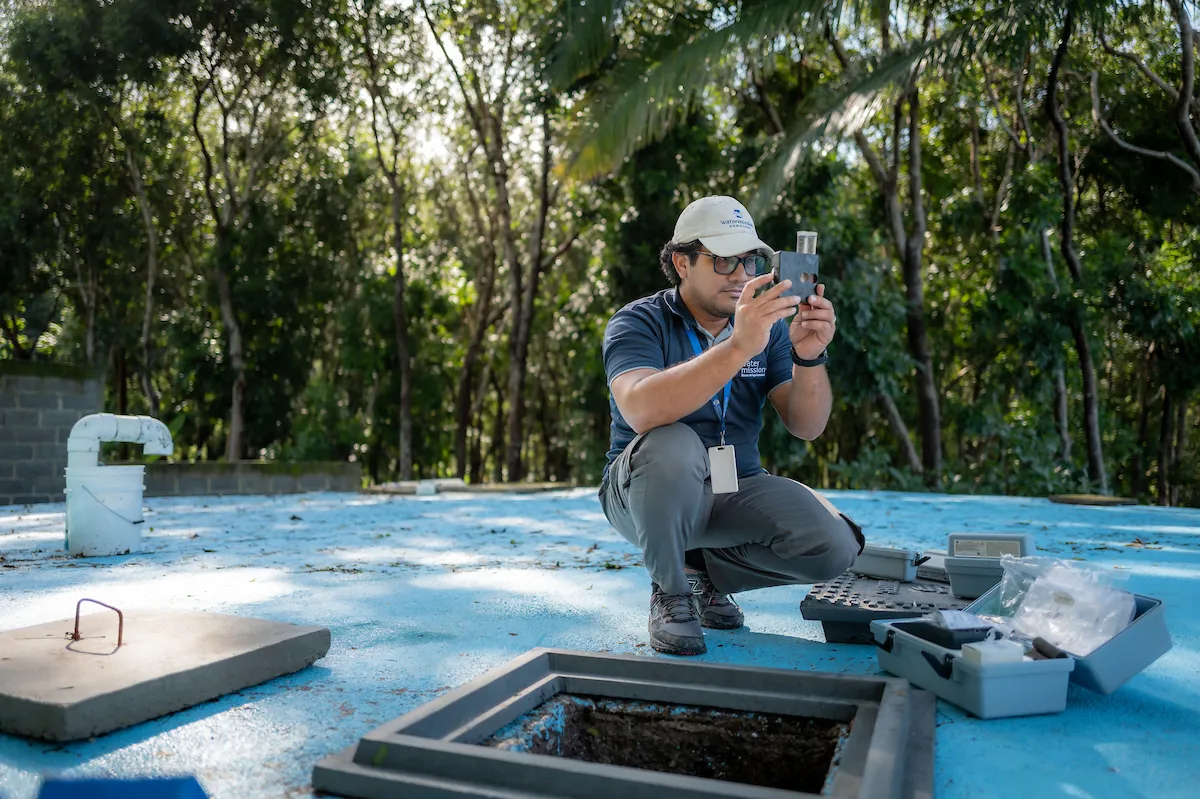 Water Mission employee performs water quality test