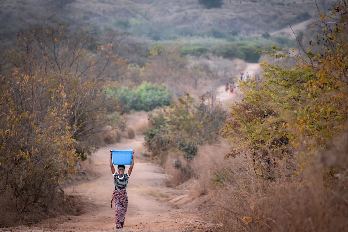 Woman carrying bucket of water