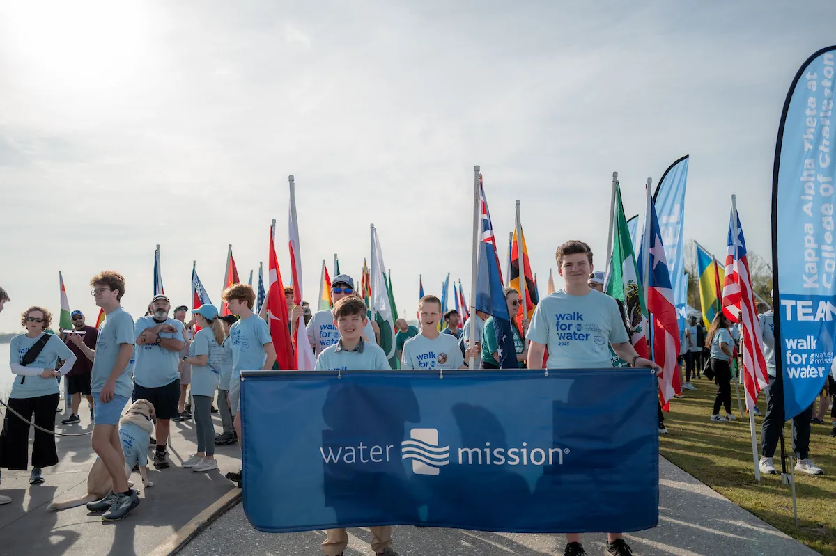 Children walk with Water Mission banner