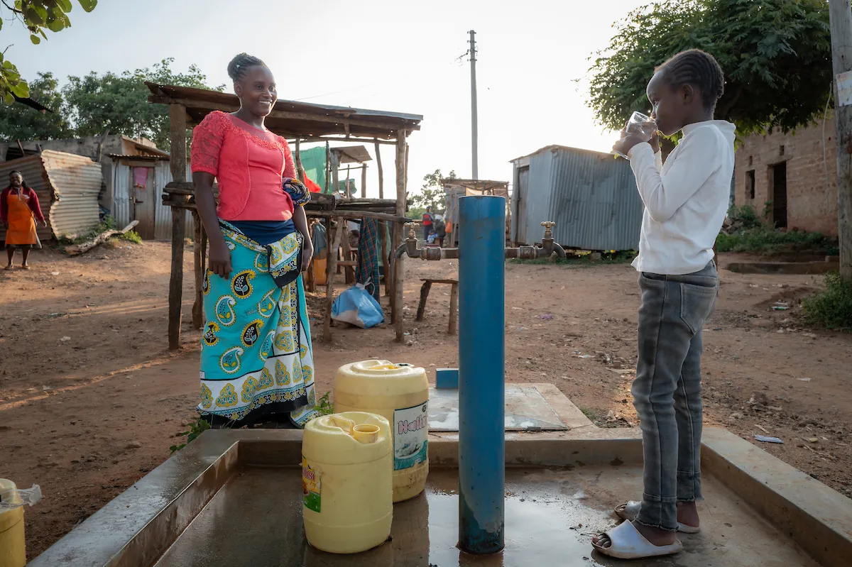 Mother and daughter at Water Mission tap stand
