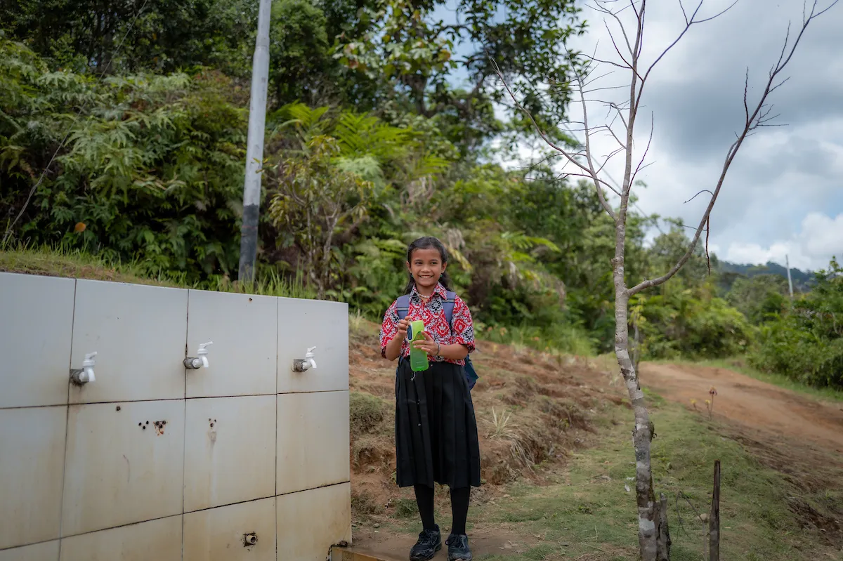 Child smiling at water access point