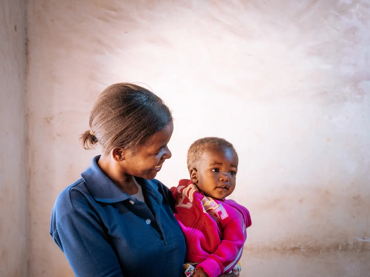 Jackline holding her daughter, Given
