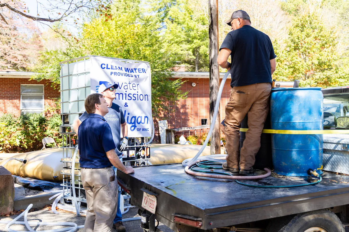 CEO and President George Greene IV talks with a person filling up a barrel with water