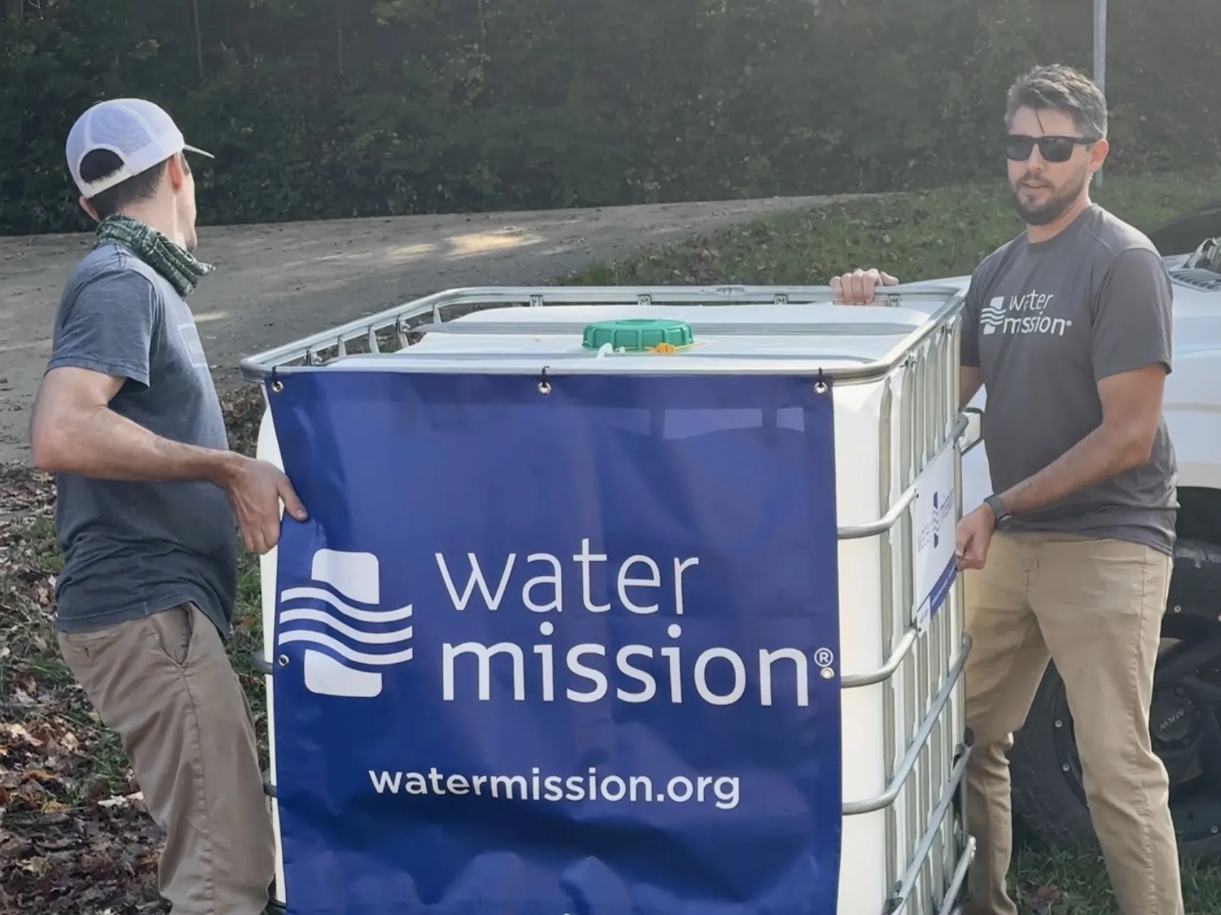 Jonathan Fawcett helps carry a Living Water Treatment System