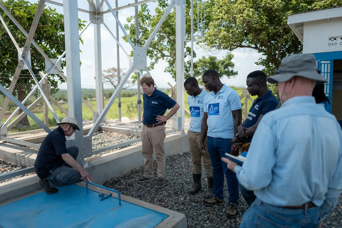 George Greene IV, Water Mission co-founder George Greene III, and Uganda staff members inspect the Omugo 5 project.