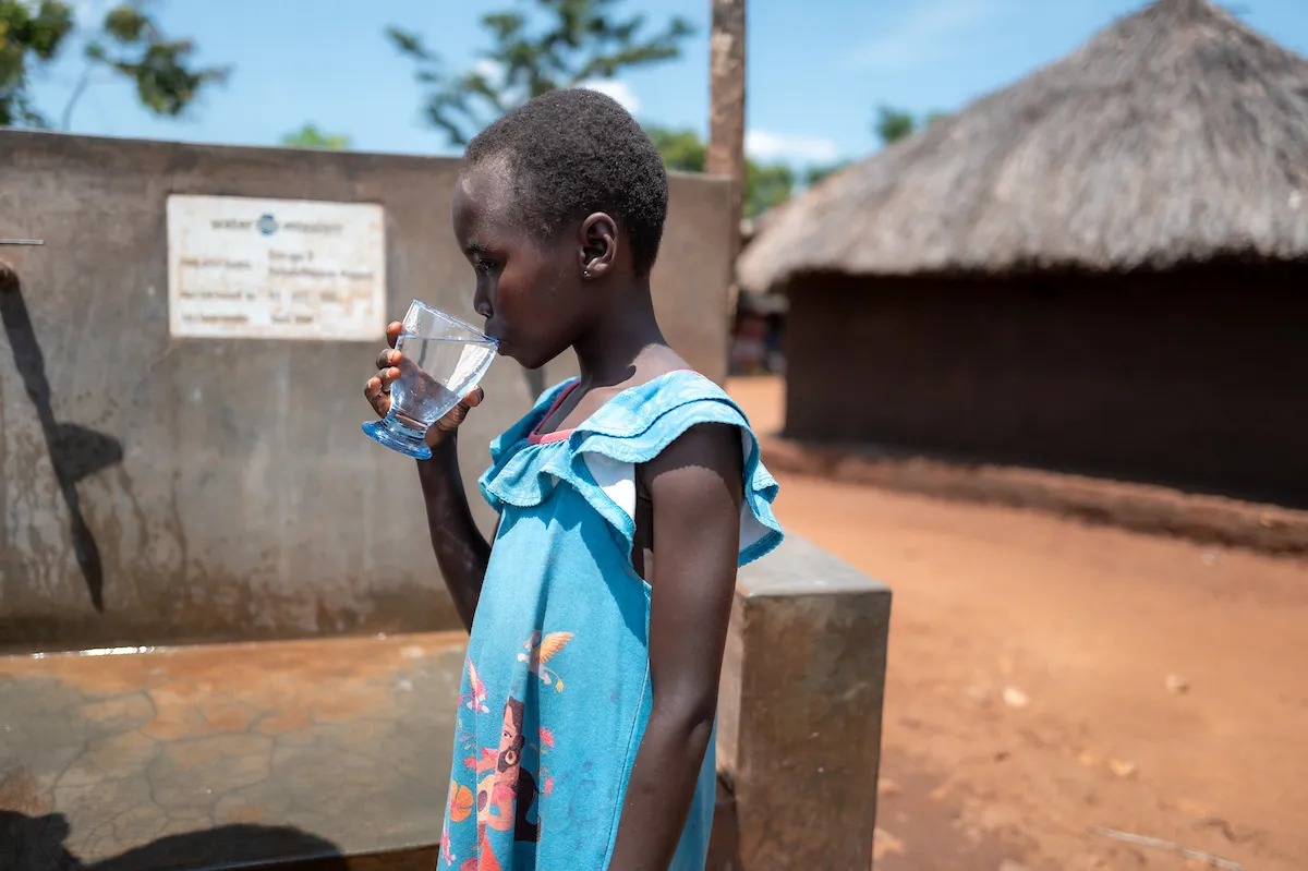 A child at Rino Camp refugee settlement in Uganda drinks clean, safe water