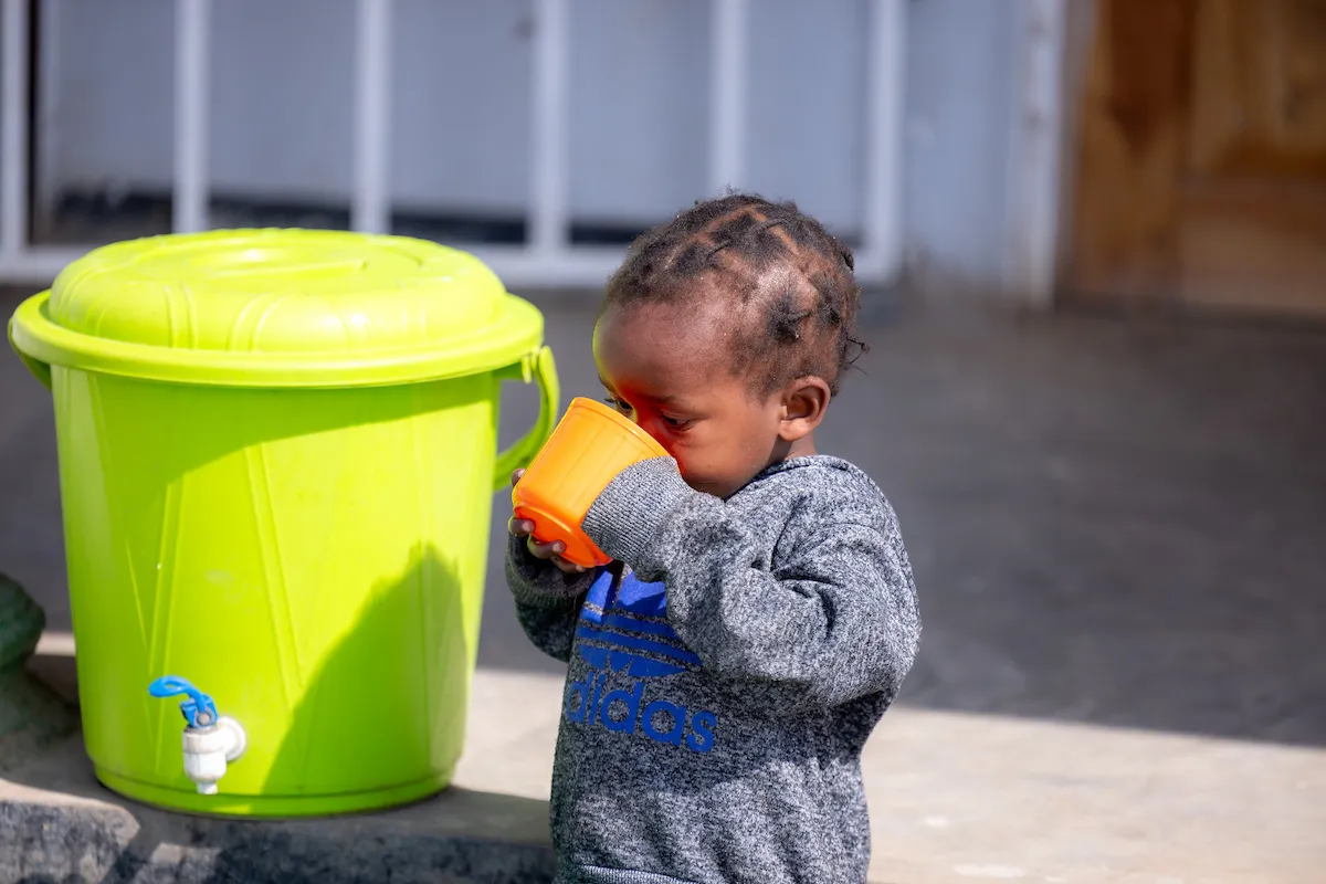 A child drinks safe water from a cup