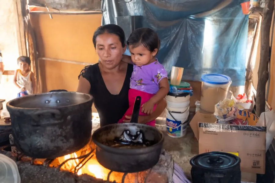 Milagros boils water in her kitchen.
