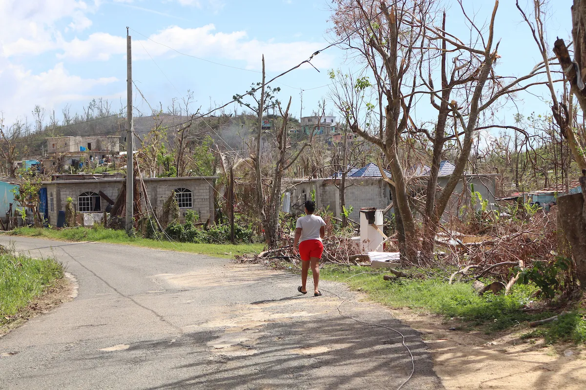 A woman walks amidst hurricane damage