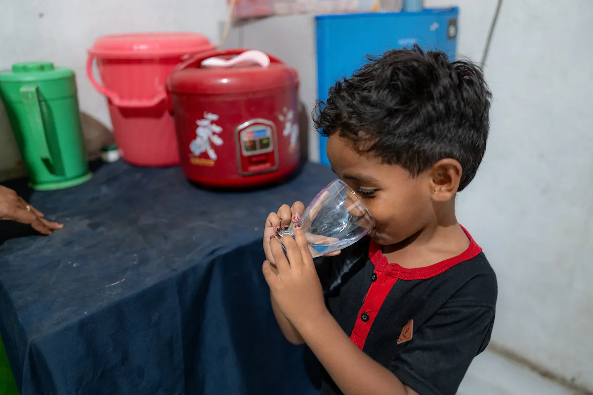 Delti's 5-year-old son Jose takes a drink of safe water