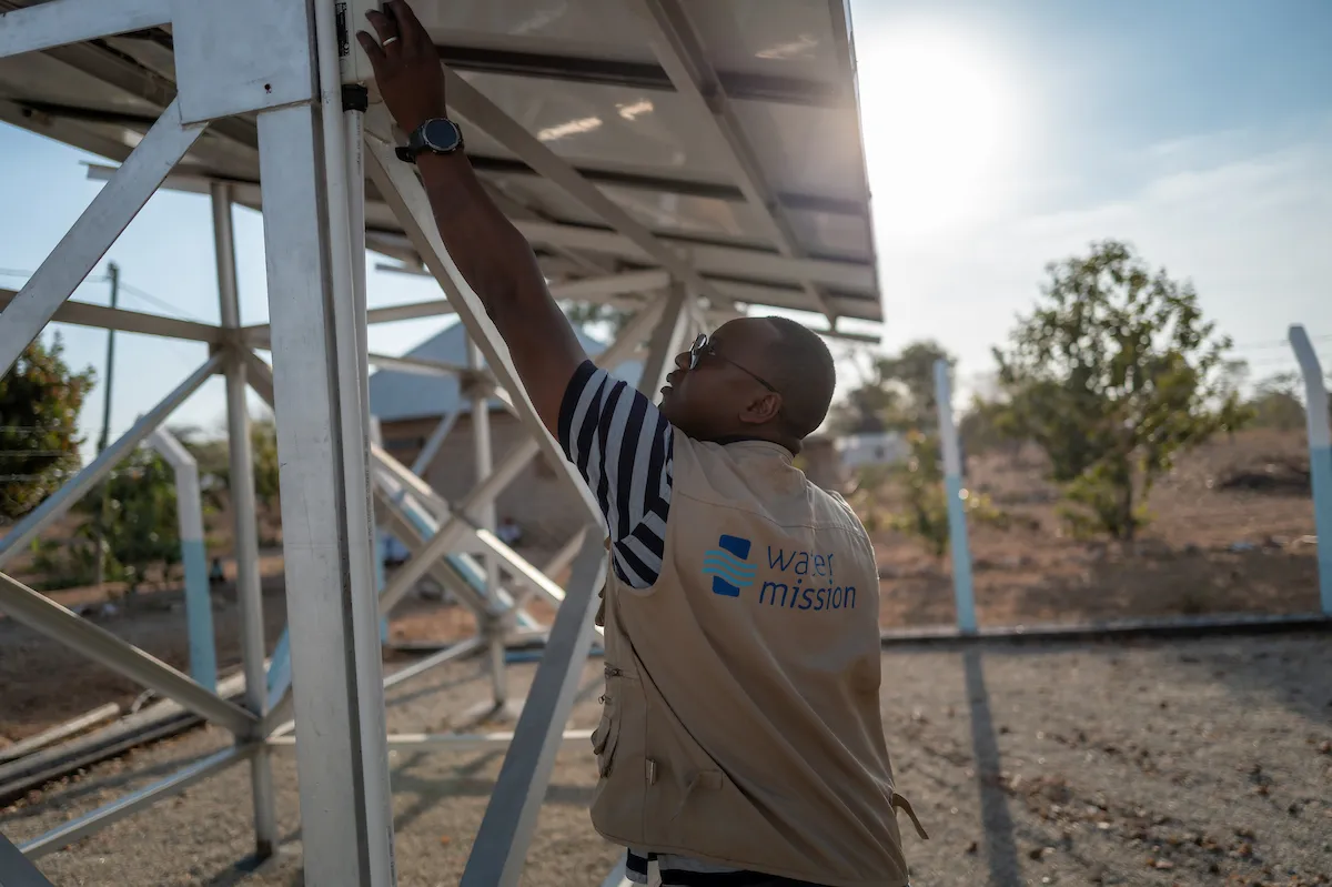 Water Mission employee checks on safe water project