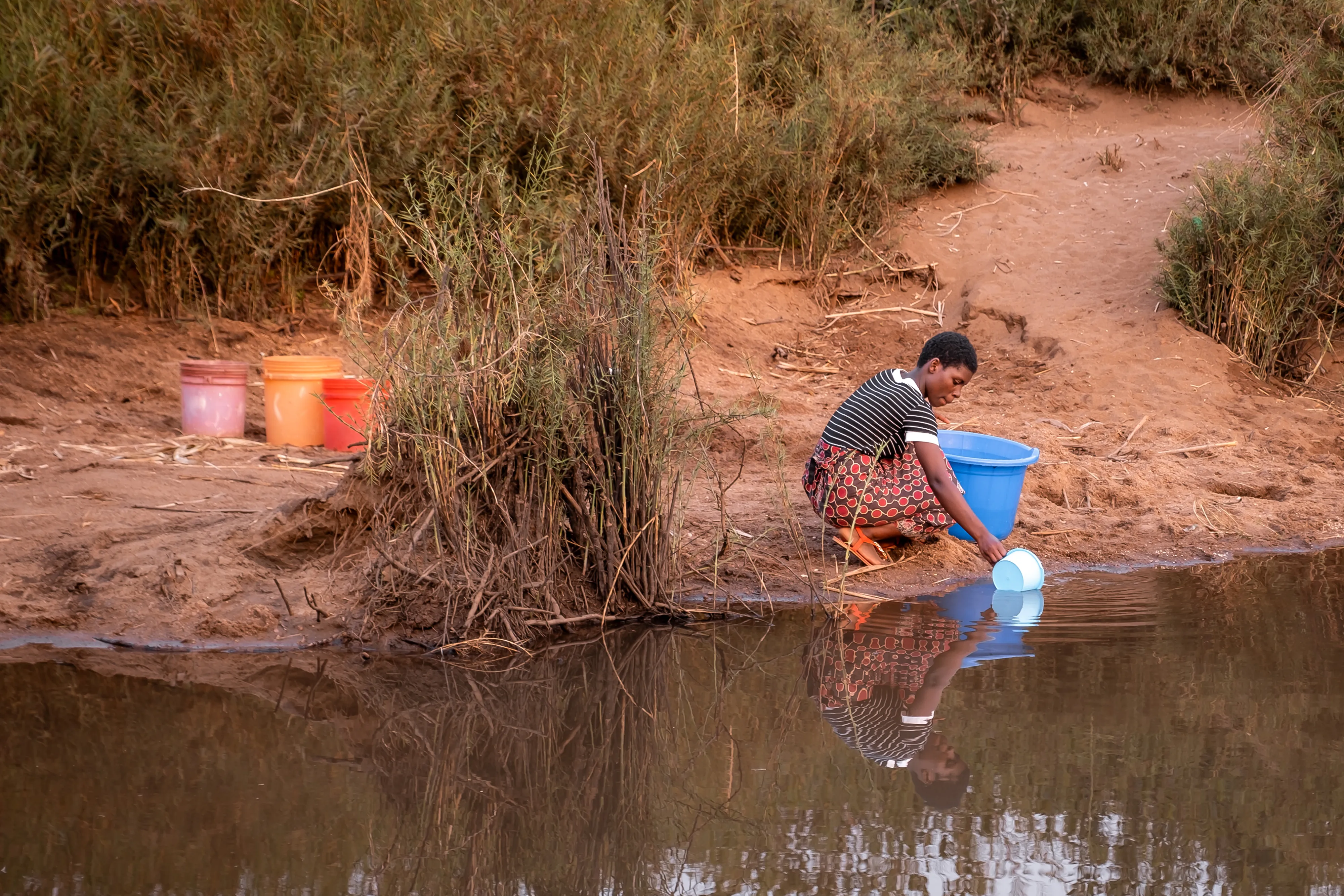 Woman collecting unsafe water