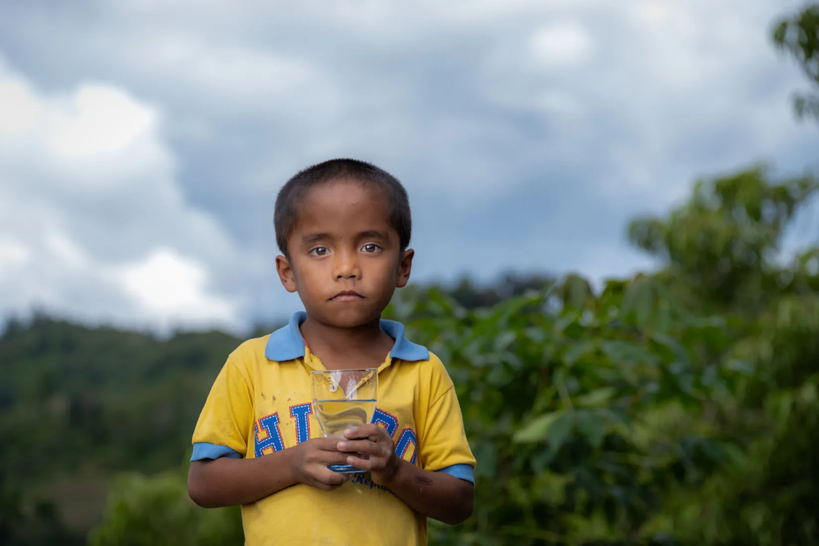 A child holds a glass of safe water