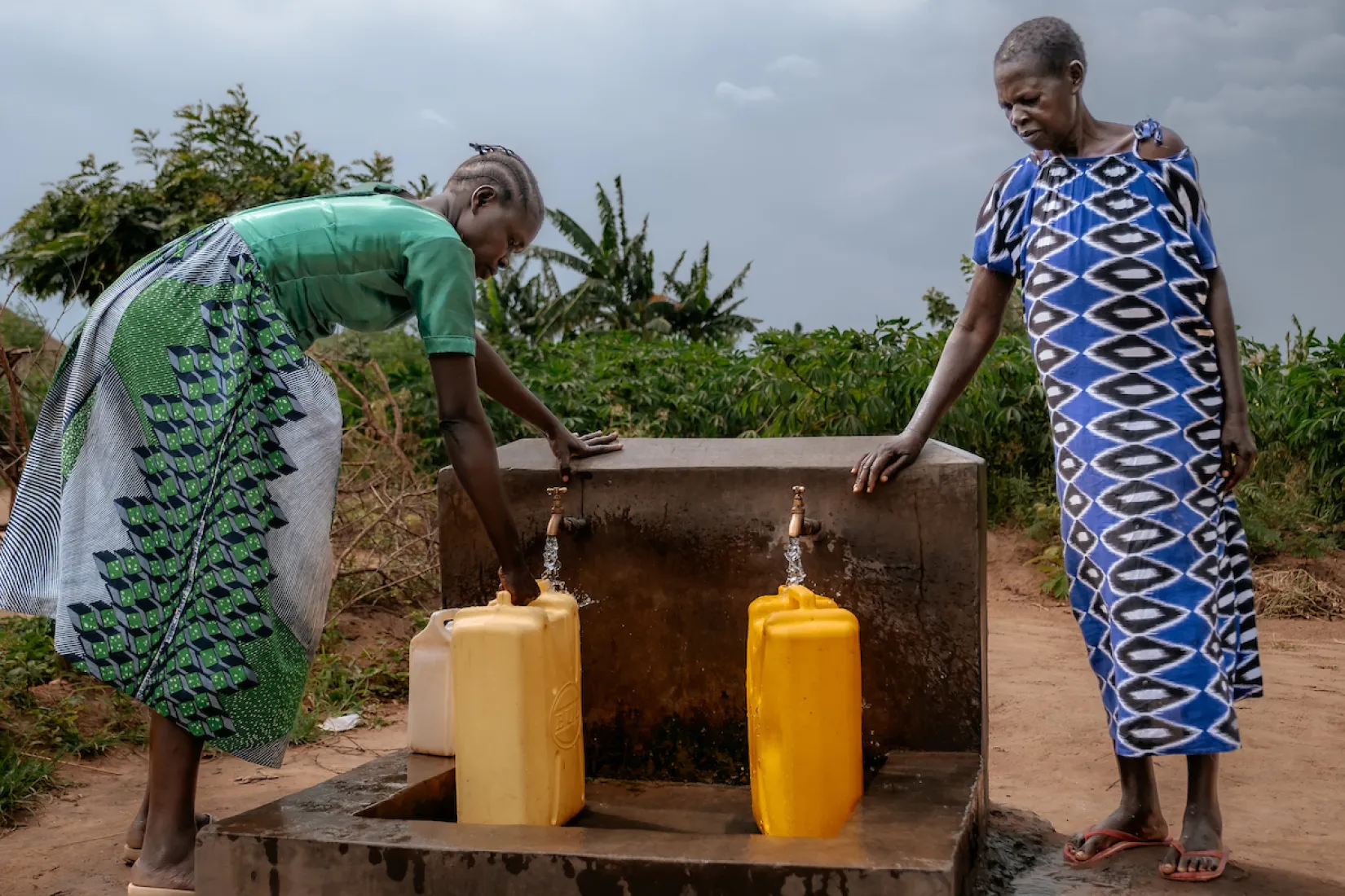 Women filling up jerry cans with water