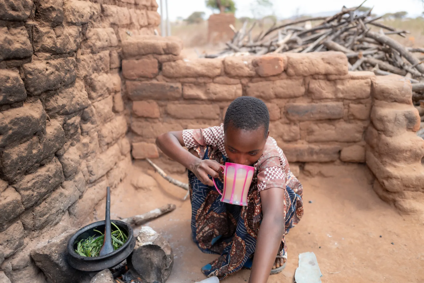Child in Tanzania, Africa drinks dirty, unsafe water