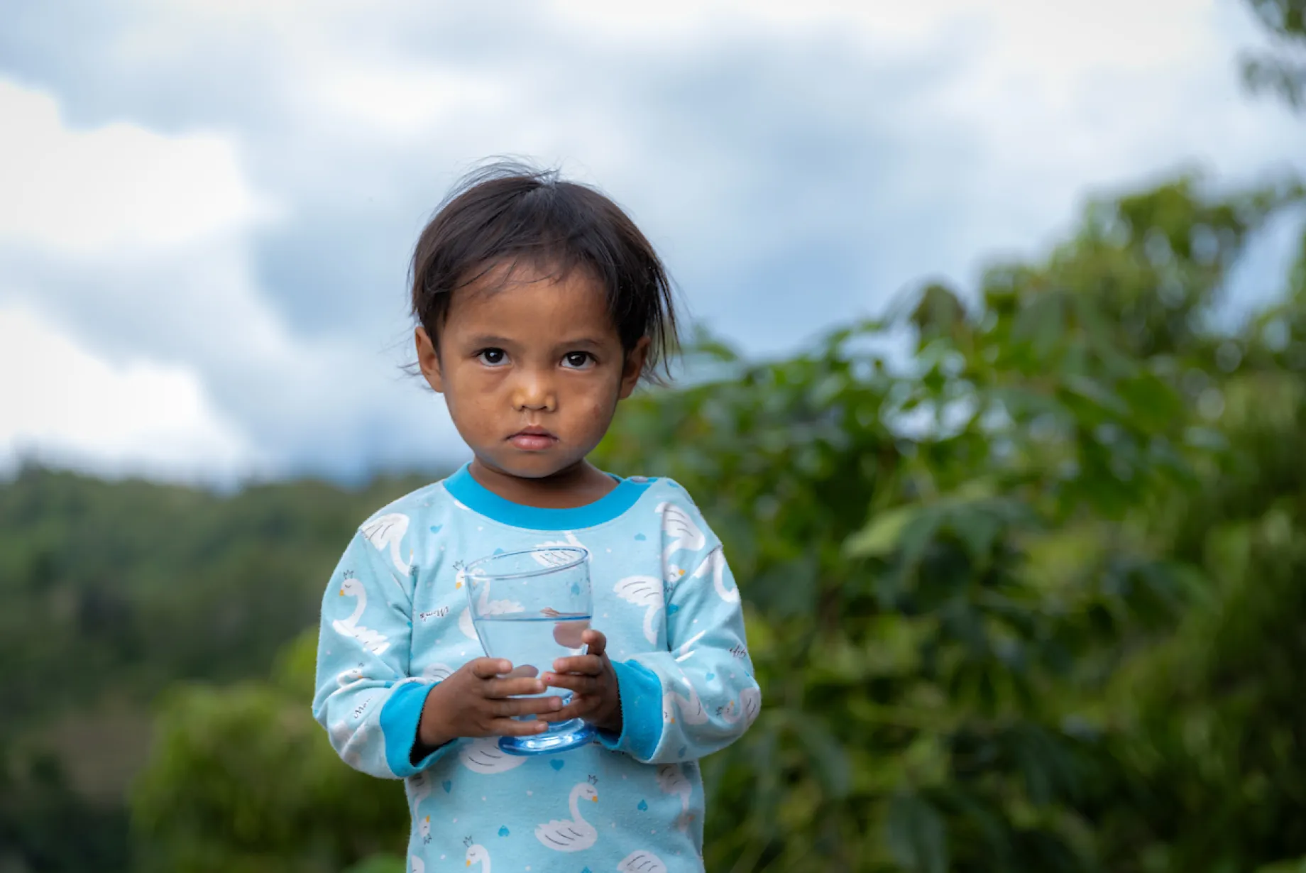 A child holds a glass of safe water