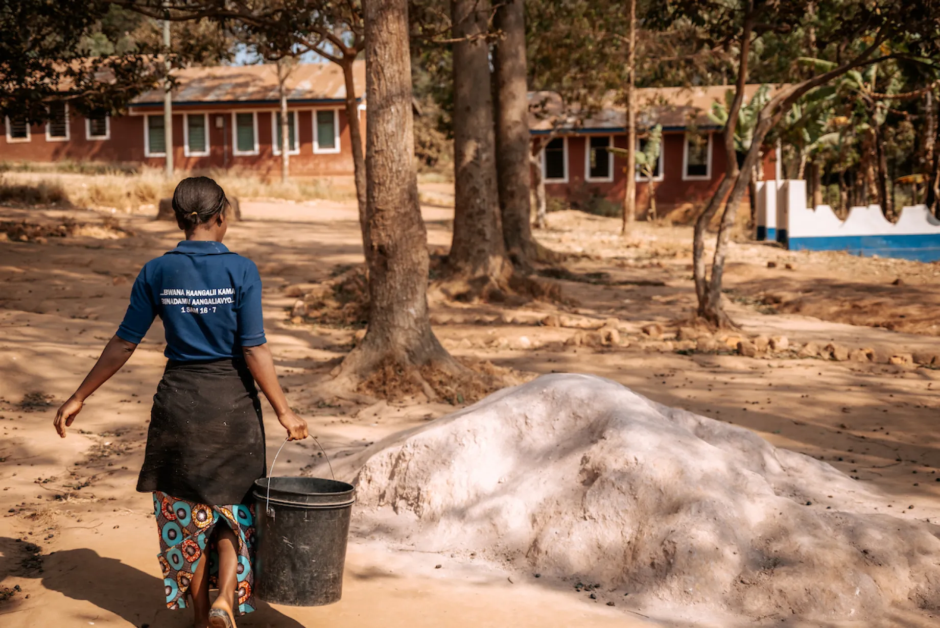 Jackline walks with bucket of water