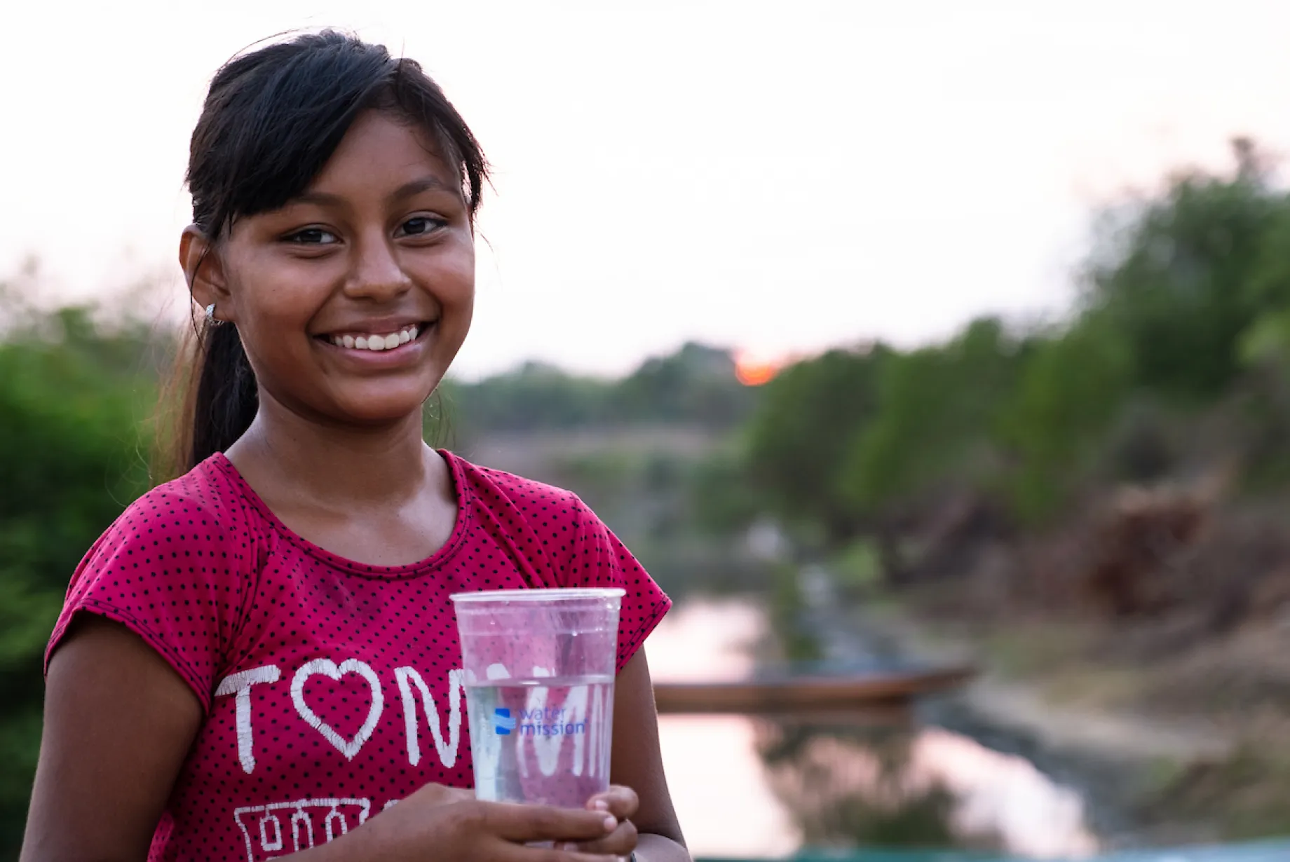 Girl smiling with cup of water