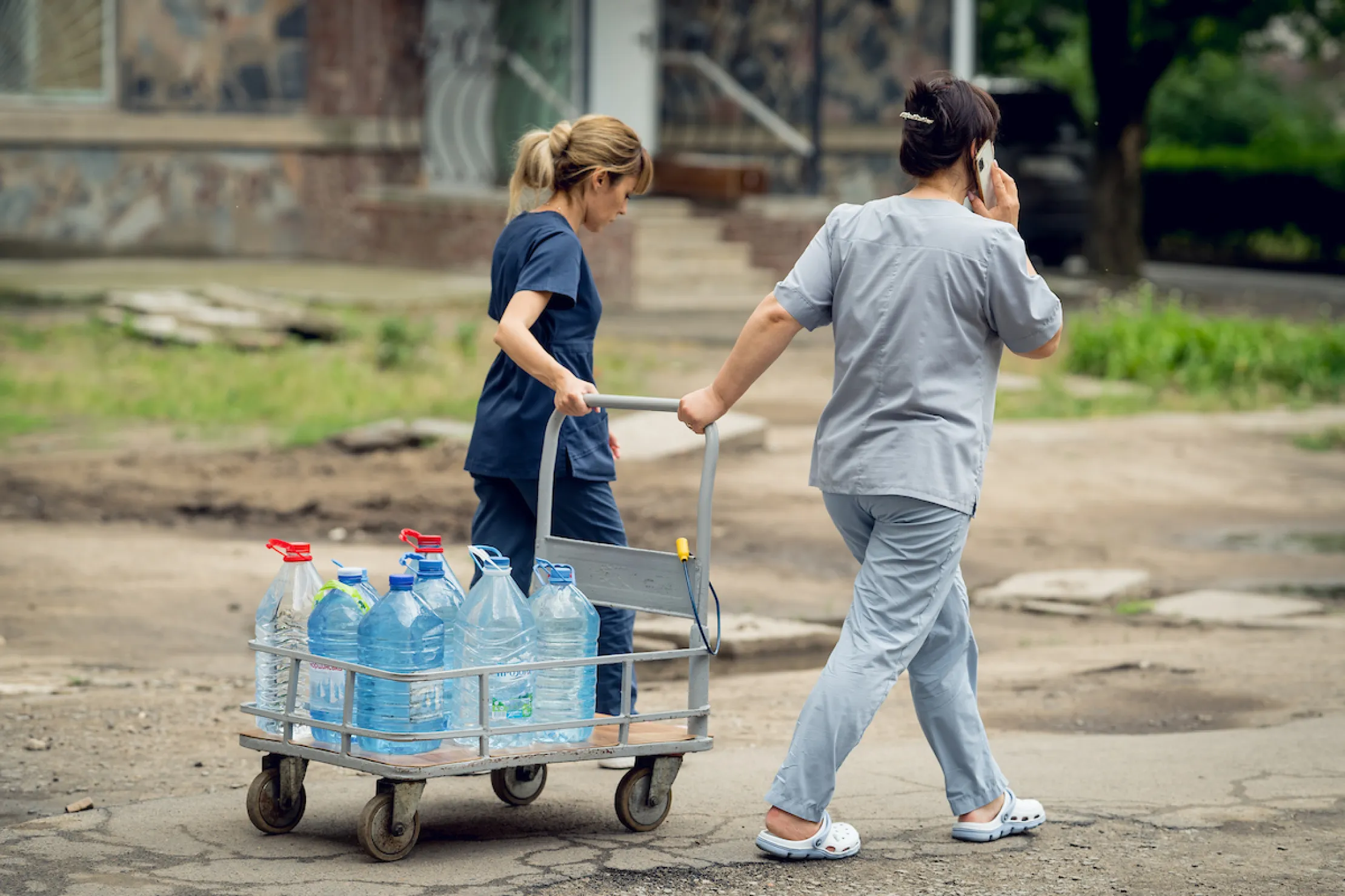 People wheeling bottles of water 