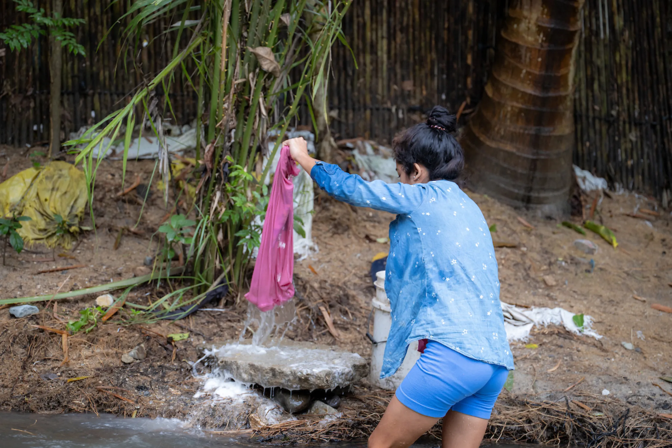 Rosa washes clothes in the river