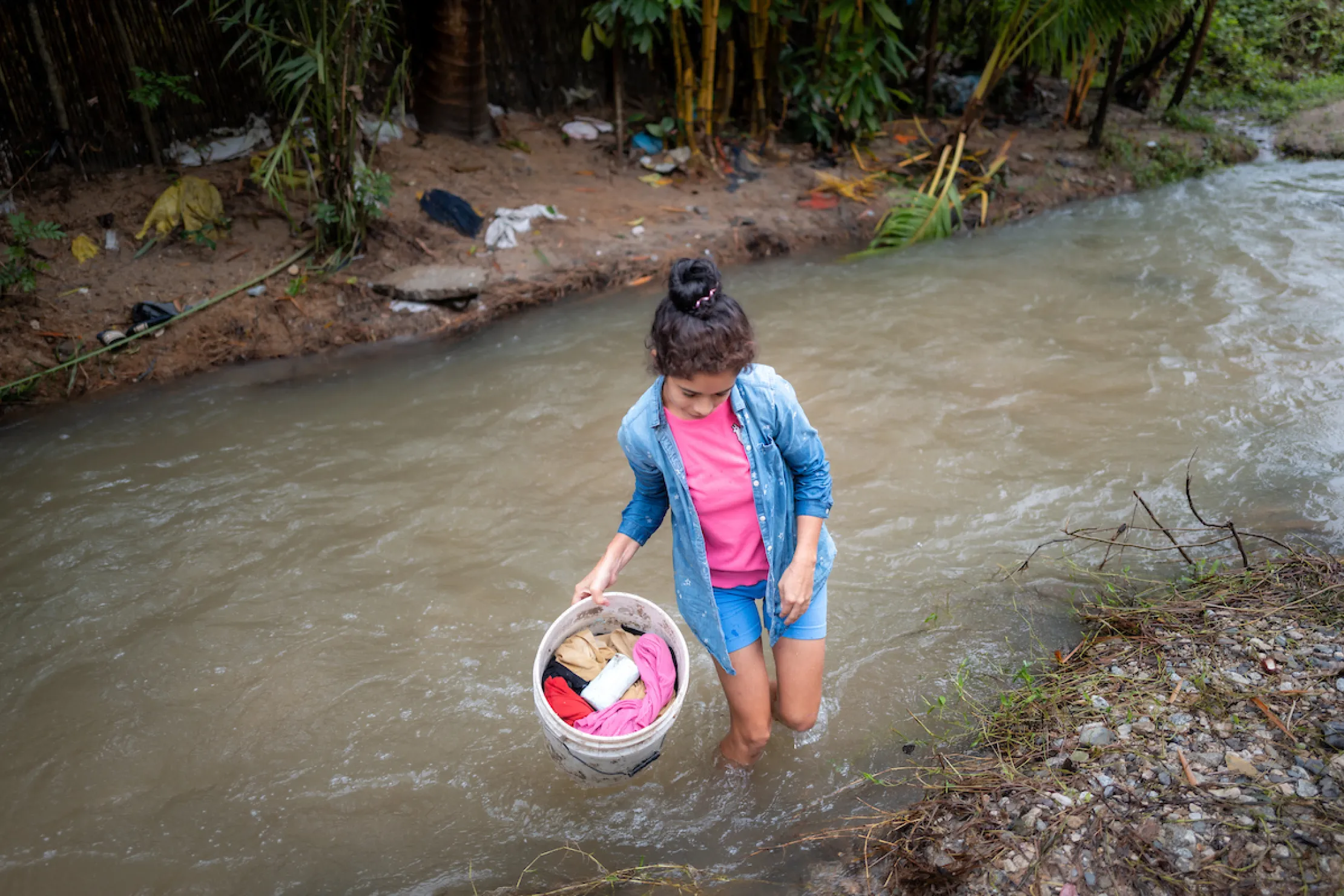 Rosa washes clothes in a river