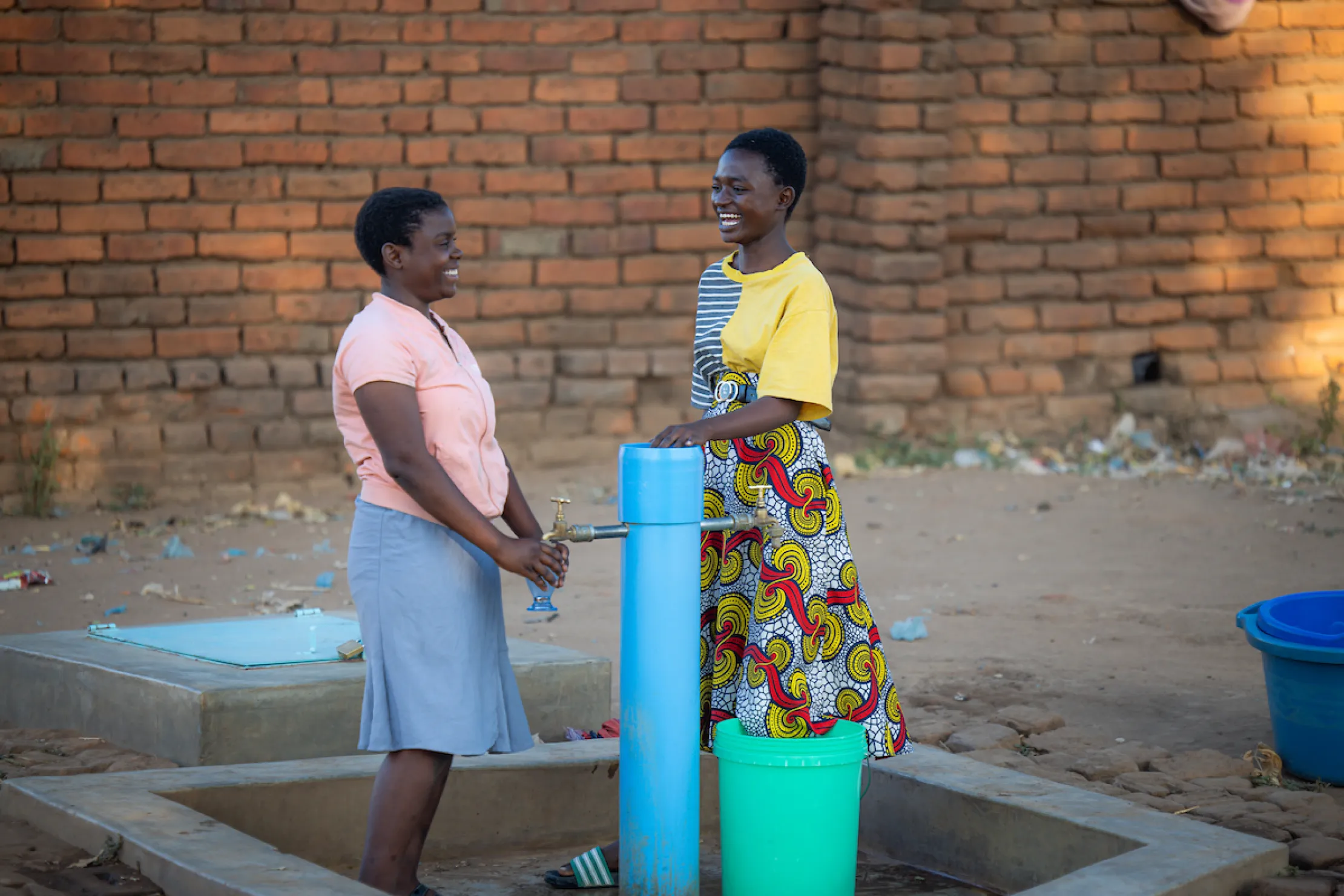 Gladys and a friend at a tapstand in Malawi