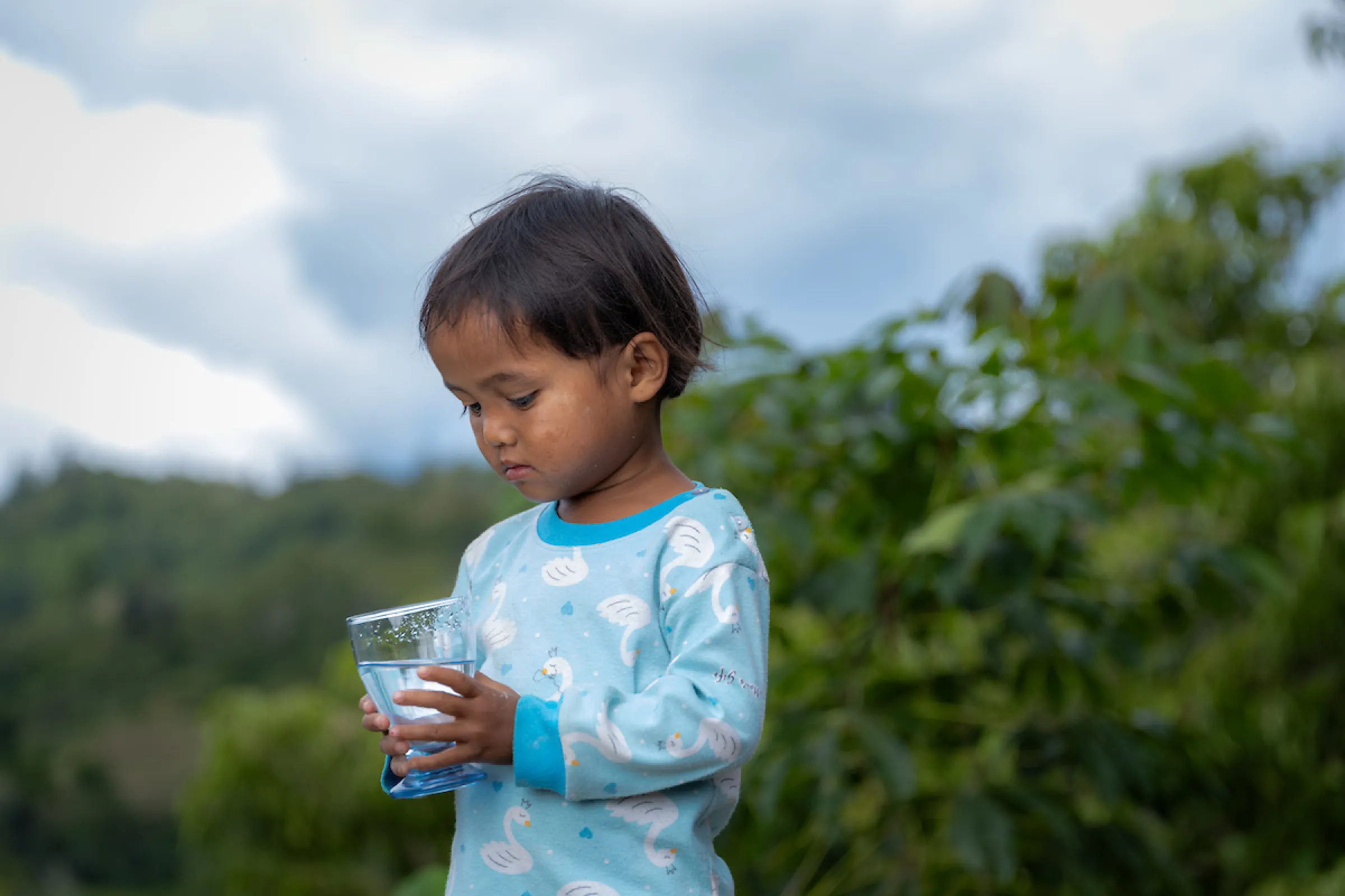 A child holds a glass of safe water