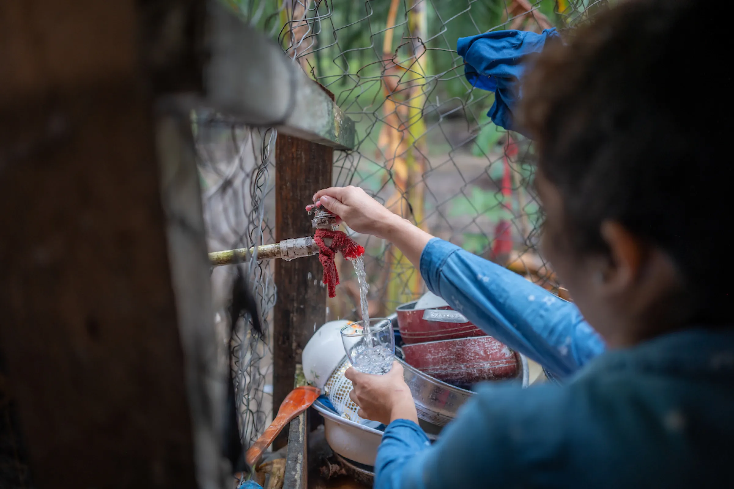 Rosa pours a glass of water