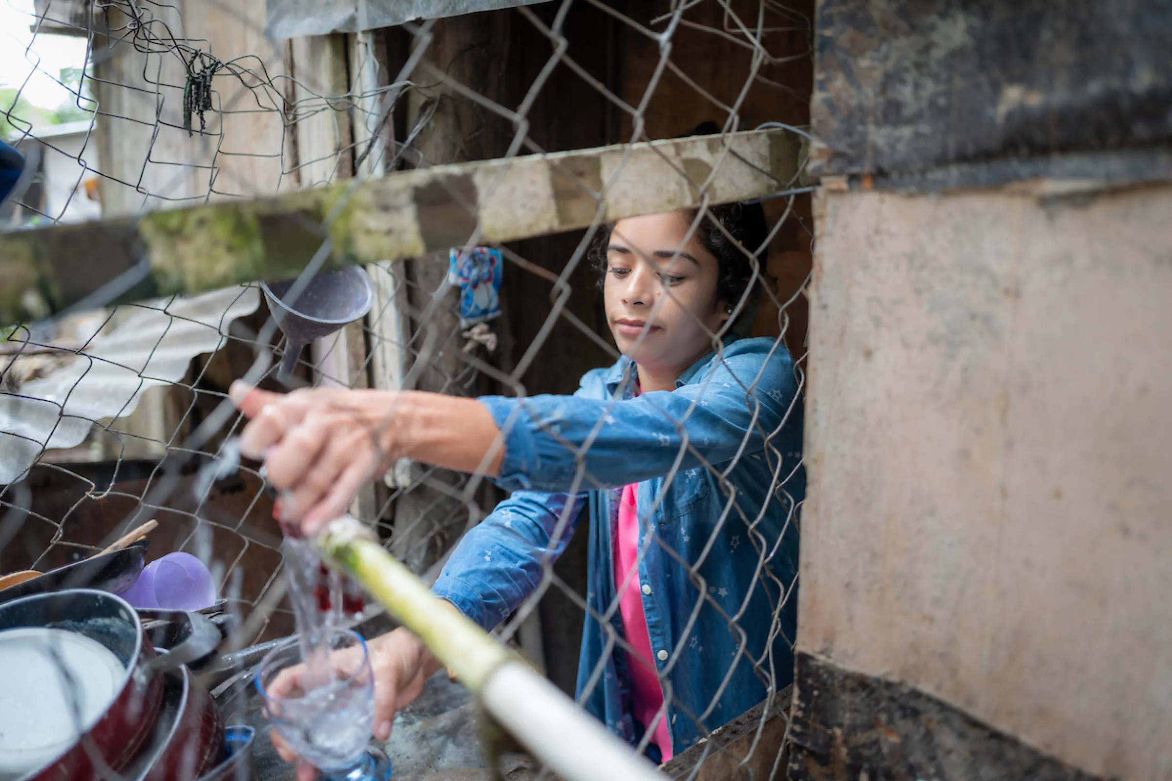 Rosa pours a glass of water