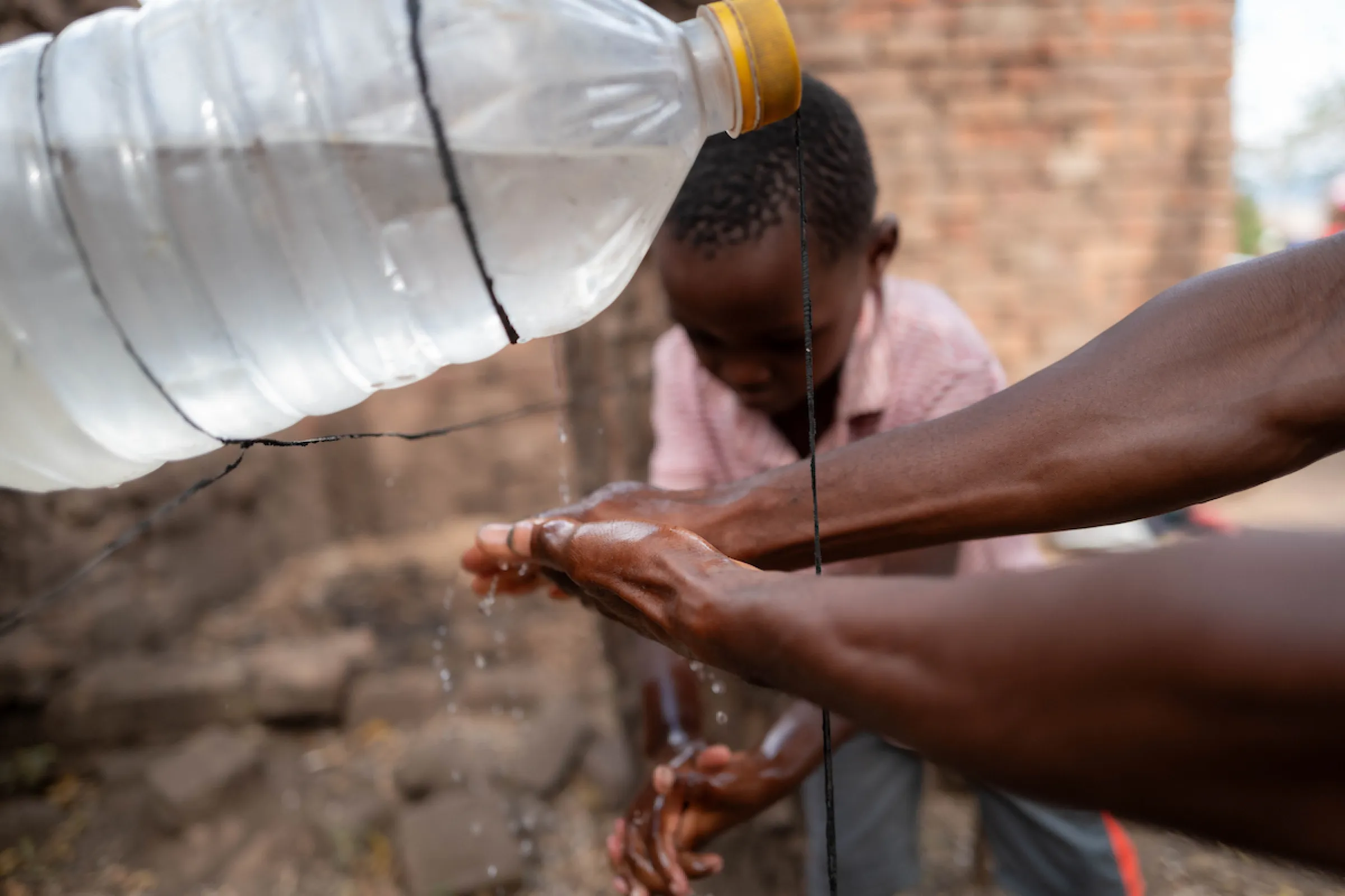 A man and child wash their hands with safe, clean water