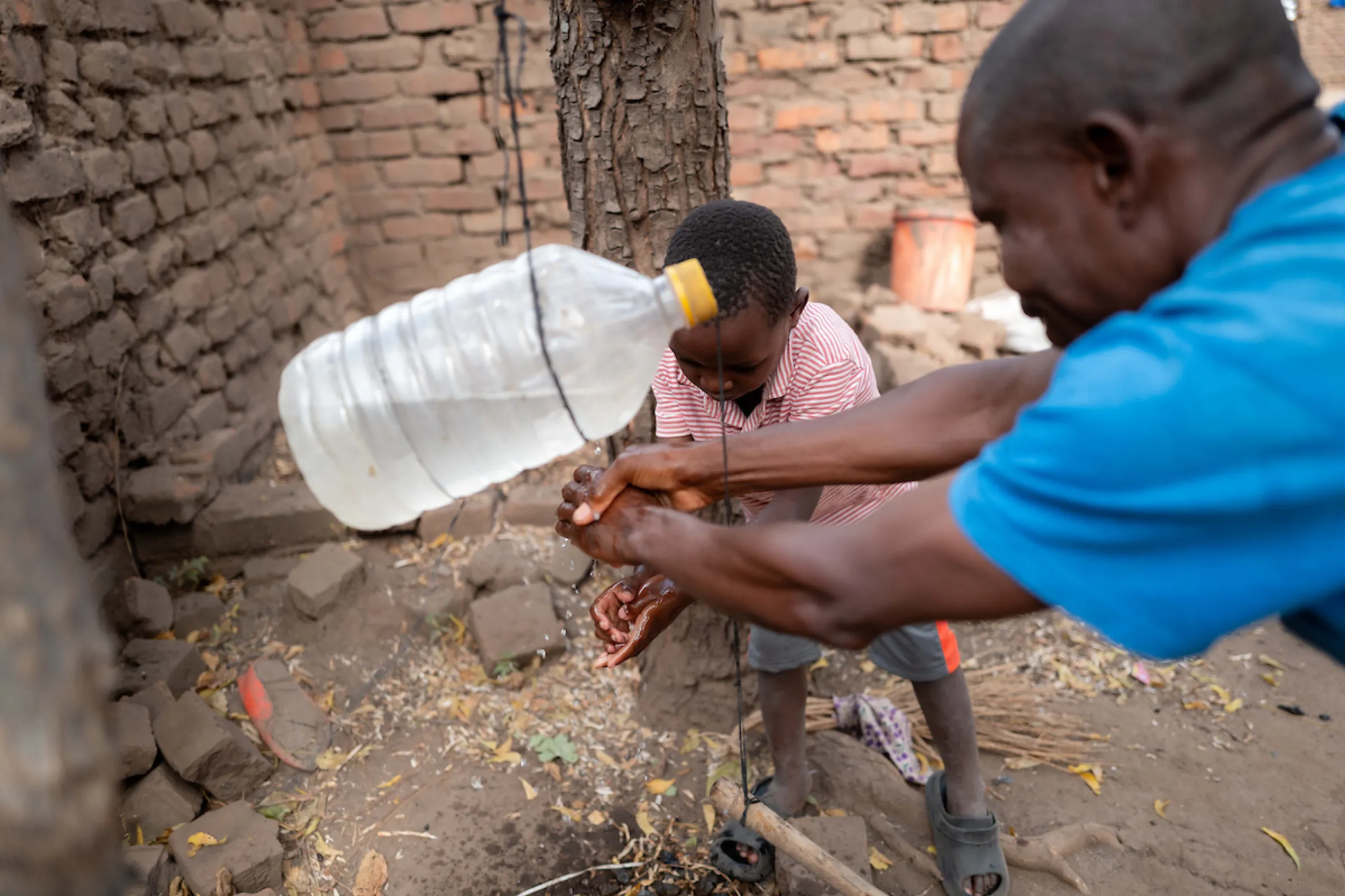 A man and child wash their hands with safe, clean water