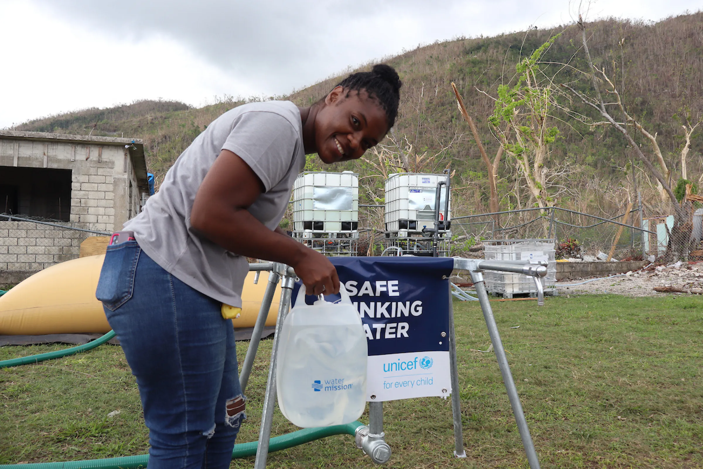 Jamaican woman smiles while accessing safe water