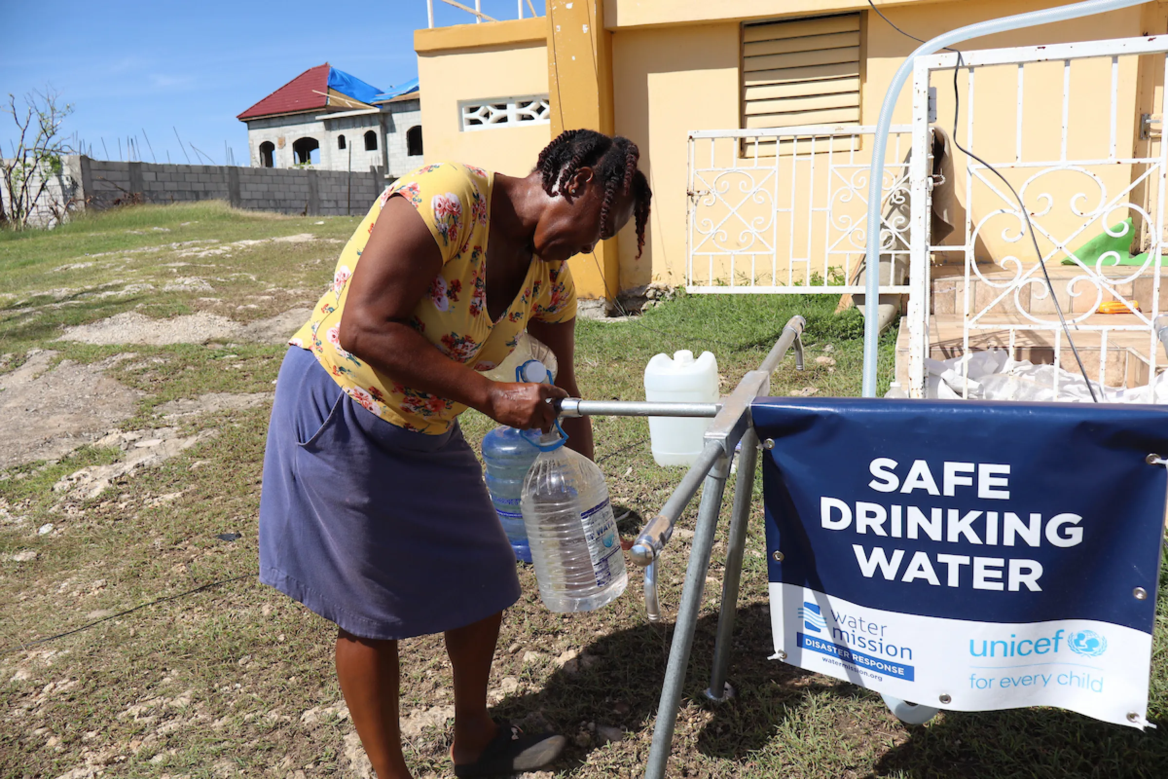 A woman in Jamaica accesses safe water after Hurricane Melissa