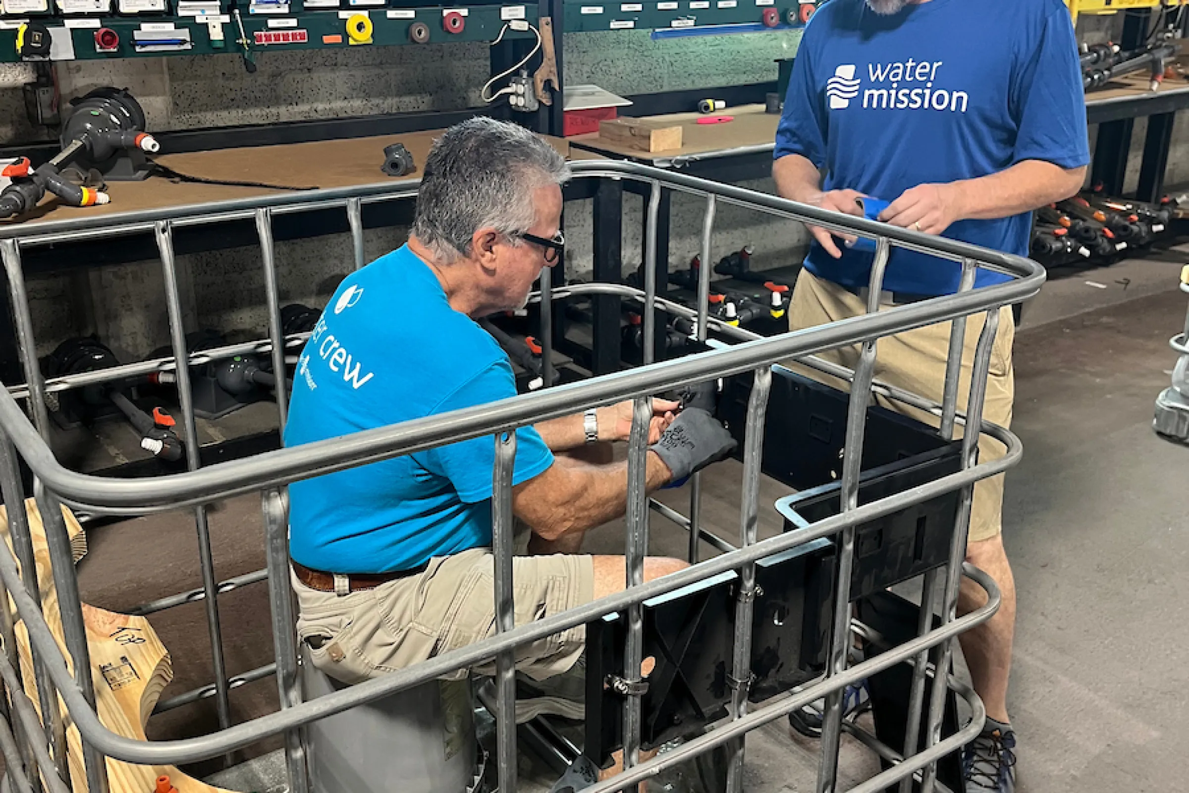 Volunteers assembling safe water equipment in the warehouse