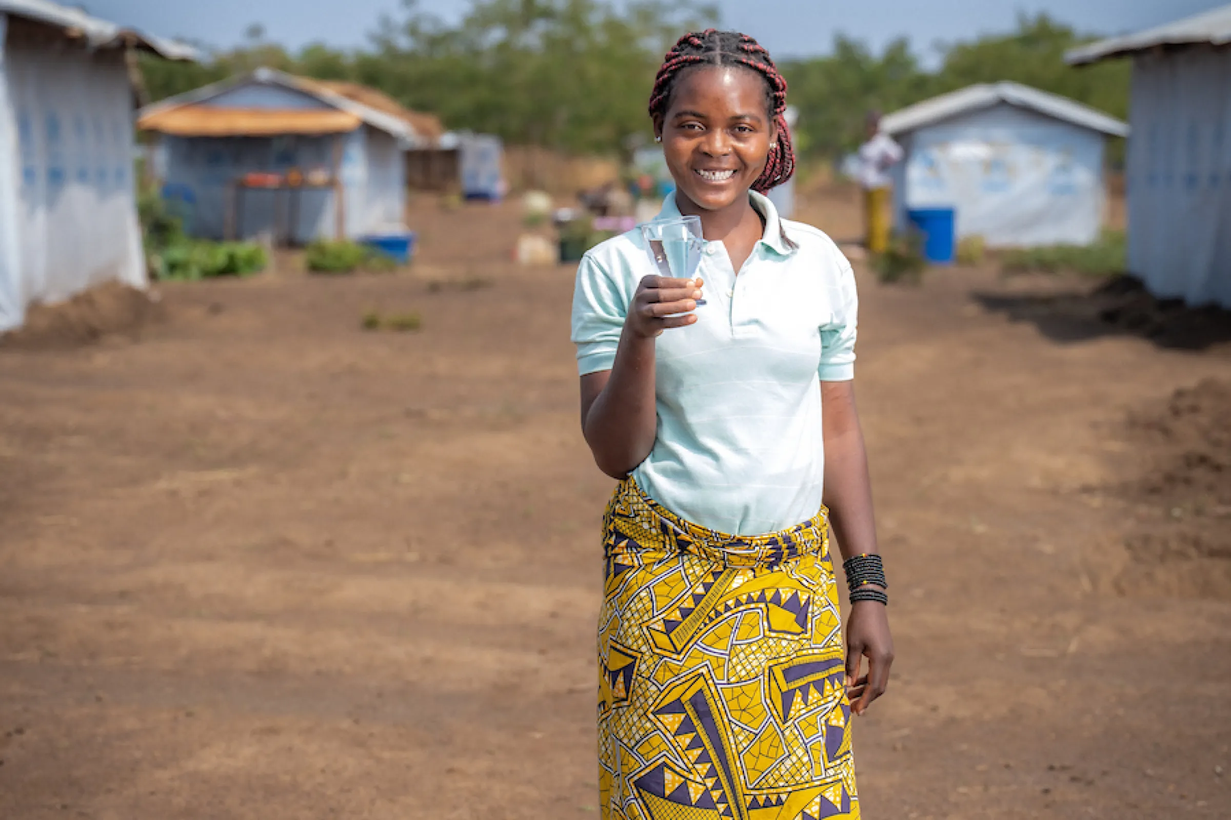 Katembo smiles with safe water; Nyarugusu Refugee Camp; Tanzania, Africa