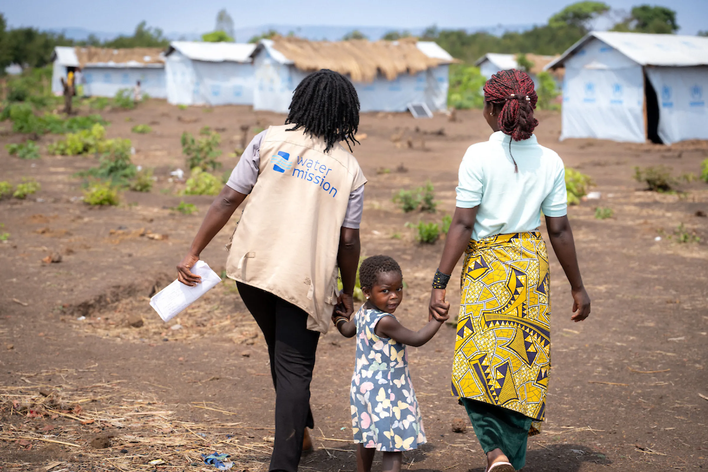 Katembo and child with Water Mission staff member; Nyarugusu Refugee Camp; Tanzania, Africa