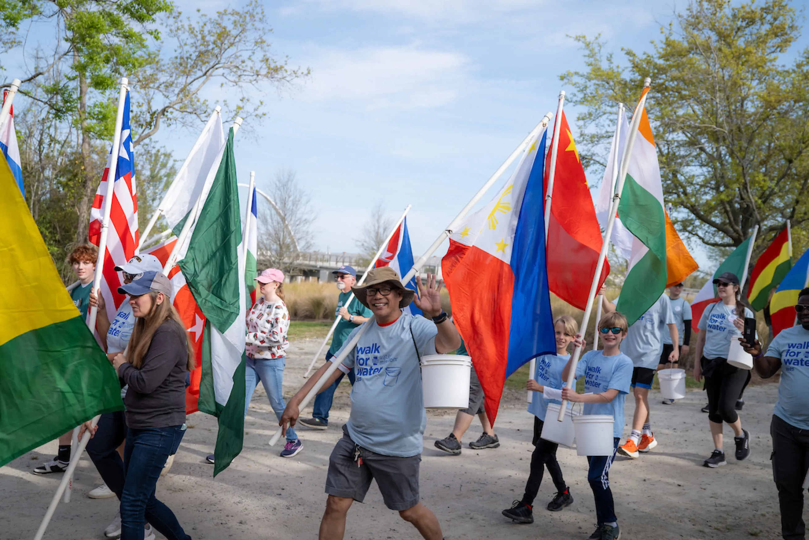 Man holding flag waves to camera
