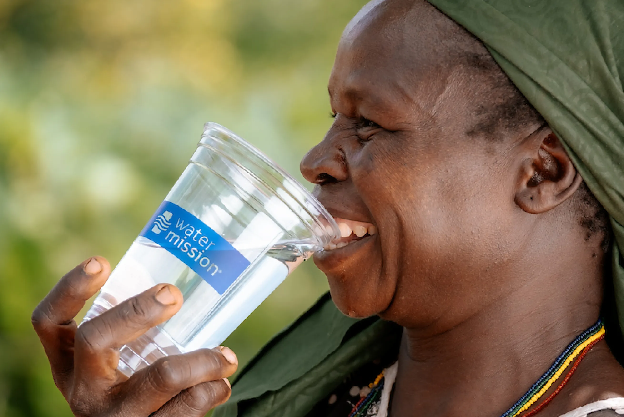 Woman smiles while drinking safe water
