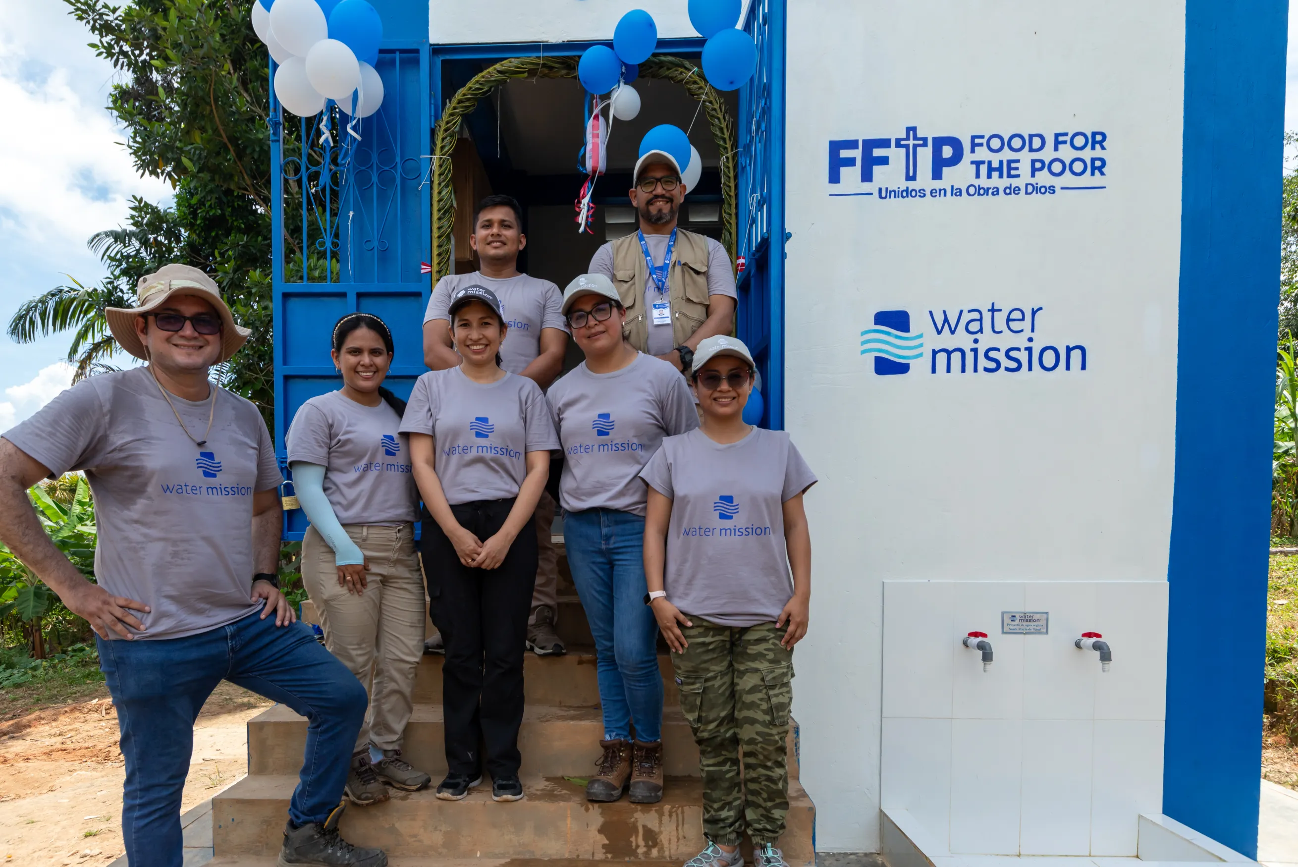 Water Mission staff in front of a safe water project