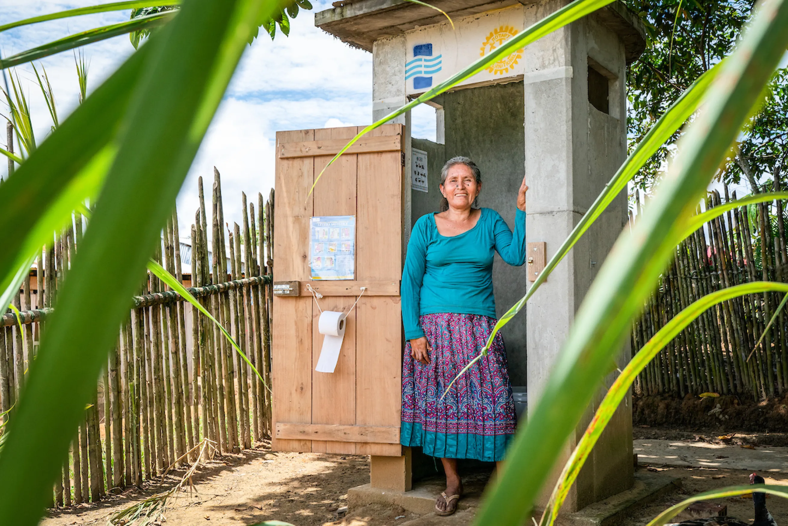 Woman stands in doorway of Healthy Latrine