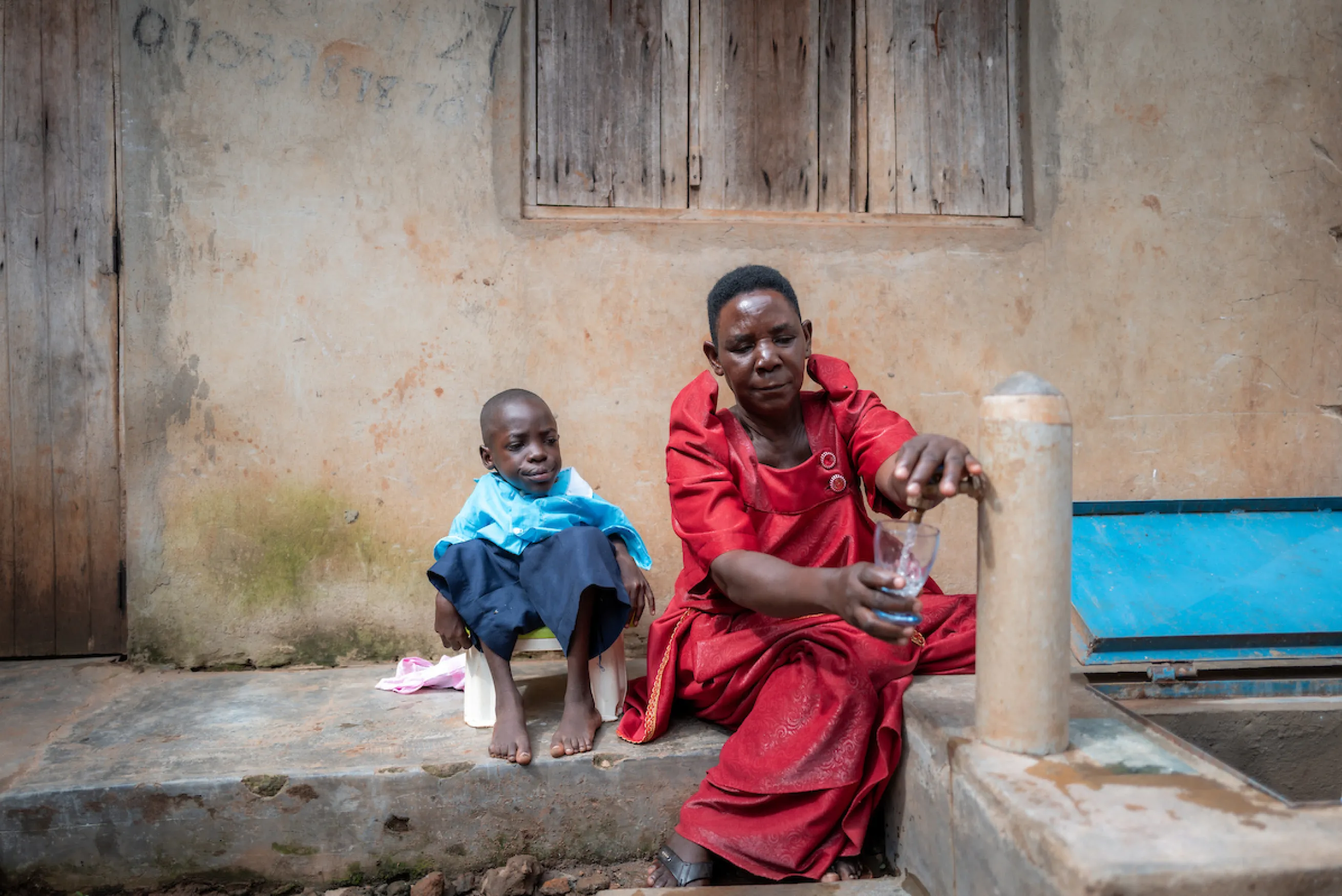 A woman and child in Uganda at a safe water tap