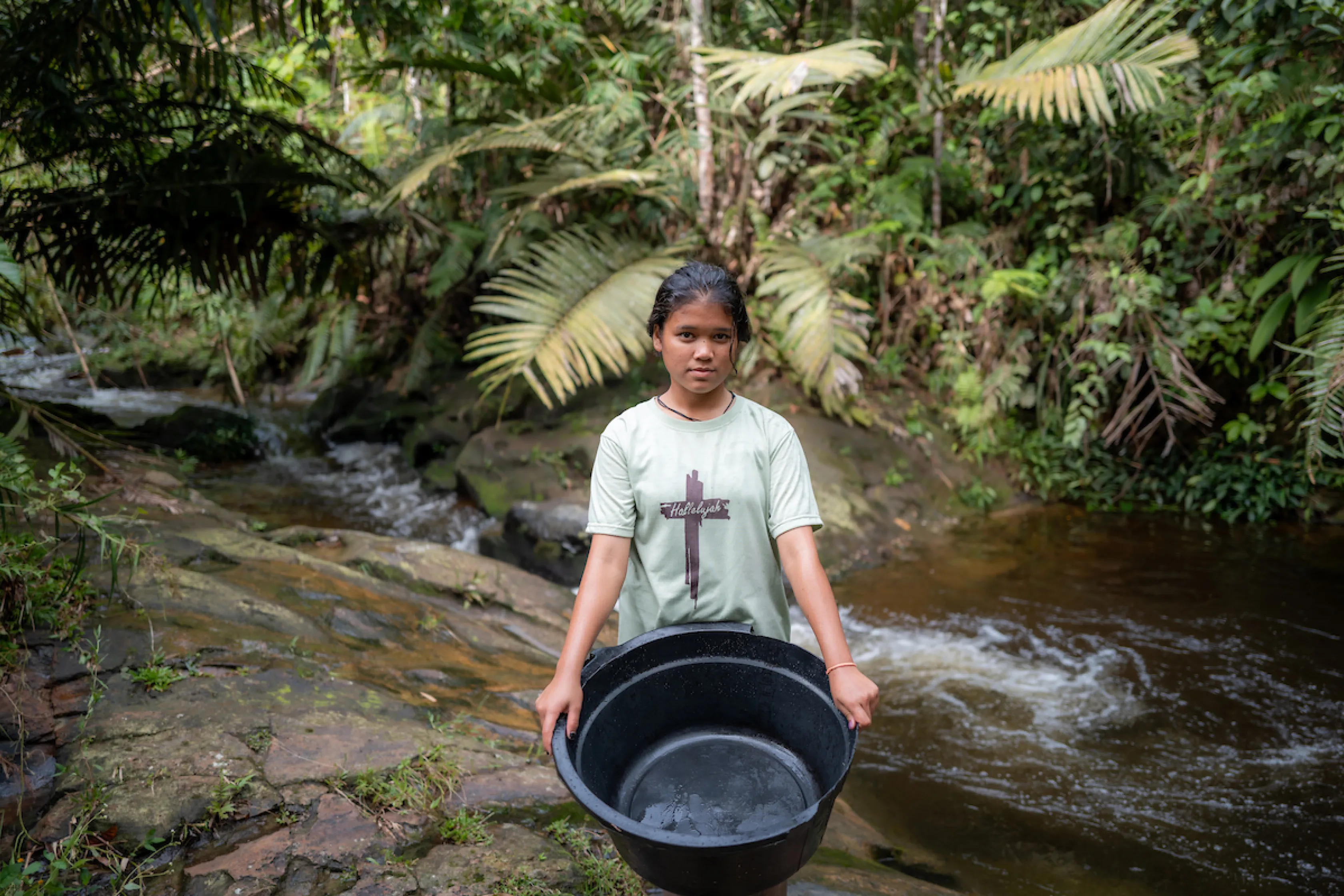 A young girl collects unsafe water